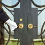 portiere di un palazzo che accoglie i condomini aprendo e chiudendo la porta